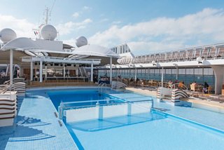 Un área soleada en la cubierta con piscina y tumbonas, perfecta para relajarse y disfrutar en el MSC Lirica | MSC Cruceros