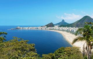 Stunning view of Copacabana beach in Rio de Janeiro with blue sea and lush greenery | MSC Cruises