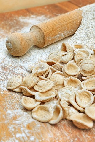 A rolling pin rests beside freshly made orecchiette pasta on a flour-dusted surface | MSC Cruises