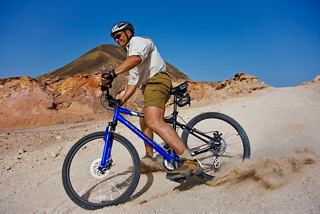 A man rides a bicycle across the sandy terrain of Sir Bani Yas Island in the United Arab Emirates | MSC Cruises