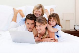 A family enjoys quality time together while planning their next adventure on a laptop in a comfortable setting | MSC Cruises