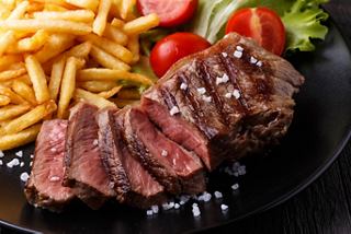 A delicious plate featuring a perfectly cooked sirloin steak, crispy fries, fresh salad, and cherry tomatoes | MSC Cruises
