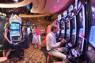 Guests enjoying a lively atmosphere at the Millennium Star Casino, engaging with slot machines on MSC Preziosa | MSC Cruises