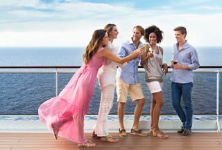 A group of friends celebrating together on the deck of MSC Preziosa, enjoying cocktails and the sea view | MSC Cruises