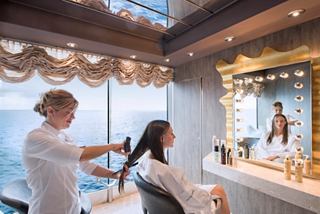 Un estilista atiende a una mujer en el área de tratamientos de belleza del MSC Aurea Spa, con vista al océano | MSC Cruceros