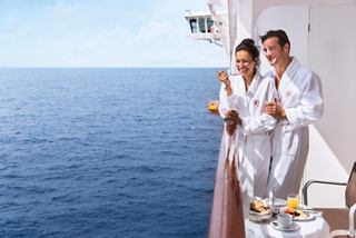 Ein Paar genießt seine Zeit zusammen auf einem Balkon mit wunderschönem Meerblick | MSC Cruises