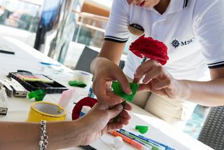 Guests participate in a hands-on arts and crafts class, creating floral decorations with guidance from the staff | MSC Cruises