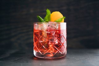 A refreshing cocktail garnished with mint and lemon, served in a clear glass | MSC Cruises