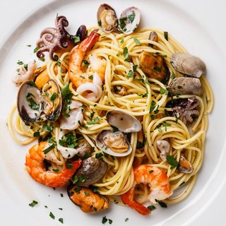 A delicious seafood pasta dish featuring shrimp, clams, and mussels, garnished with parsley | MSC Cruises