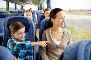 Una madre y su hijo disfrutan de un viaje en autobús juntos, mientras el niño señala emocionado, mientras otros pasajeros se relajan | MSC Cruceros