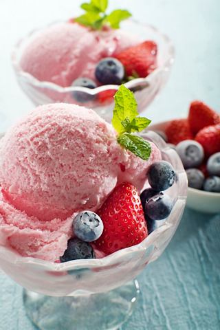 Delicious scoops of strawberry ice cream topped with fresh berries and mint leaves in elegant glass bowls | MSC Cruises