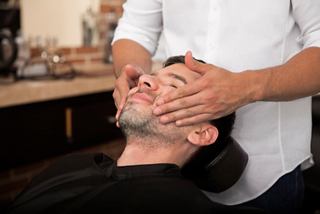A man receives a relaxing facial massage at the MSC Aurea Spa barber shop | MSC Cruises