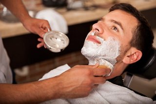 A man receiving a traditional shave at the barber shop in MSC Aurea Spa | MSC Cruises