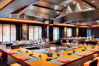 A vibrant dining area featuring the Kaito Sushi Bar & Teppanyaki with warm lighting and spacious seating | MSC Cruises