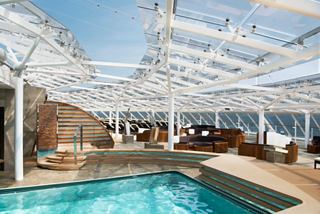 Espace autour de la piscine avec chaises longues et tables, baigné de lumière du soleil | MSC Croisières