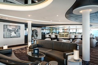 A stylish Sky Lounge with comfortable seating and a bar counter, inviting guests to relax and enjoy | MSC Cruises