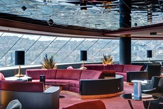 A stylish sitting area in the Top Sail Lounge of the MSC Yacht Club with panoramic windows and elegant furnishings | MSC Cruises
