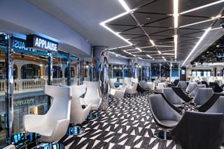 A stylish sitting area in the TV Studio & Bar, featuring modern furnishings and large windows overlooking the promenade | MSC Cruises
