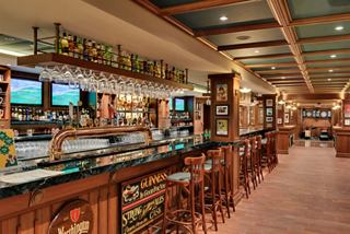 A welcoming bar area with a wooden counter and seating, perfect for enjoying a drink aboard MSC Meraviglia | MSC Cruises