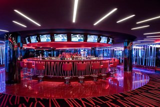 A vibrant casino bar counter with stylish seating and ambient lighting on MSC Meraviglia | MSC Cruises