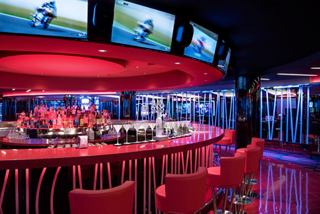 A vibrant casino area featuring a stylish bar counter and multiple monitors, inviting guests to enjoy their experience | MSC Cruises