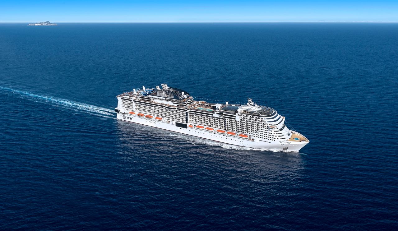 The MSC Meraviglia gracefully sails through the serene sea under a clear sky | MSC Cruises