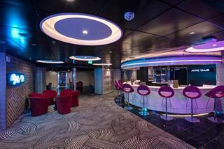 A stylish lounge area featuring a bar counter and seating, inviting guests to enjoy relaxing moments together | MSC Cruises