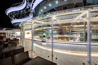 A vibrant bar area on MSC Meraviglia, featuring seating and a welcoming atmosphere for guests to enjoy at night | MSC Cruises