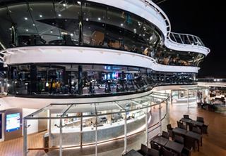 A view of the MSC Meraviglia's deck area featuring public spaces and the gym illuminated at night | MSC Cruises