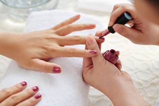A relaxing manicure experience with a hand being painted in rich nail polish at MSC Aurea Spa | MSC Cruises