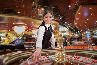 Un assistant de casino amical est prêt à accueillir les invités à la table de roulette, enrichissant l'expérience à bord | MSC Cruises