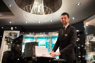 A crew member presents a selection of jewellery to guests in a vibrant onboard shop | MSC Cruises
