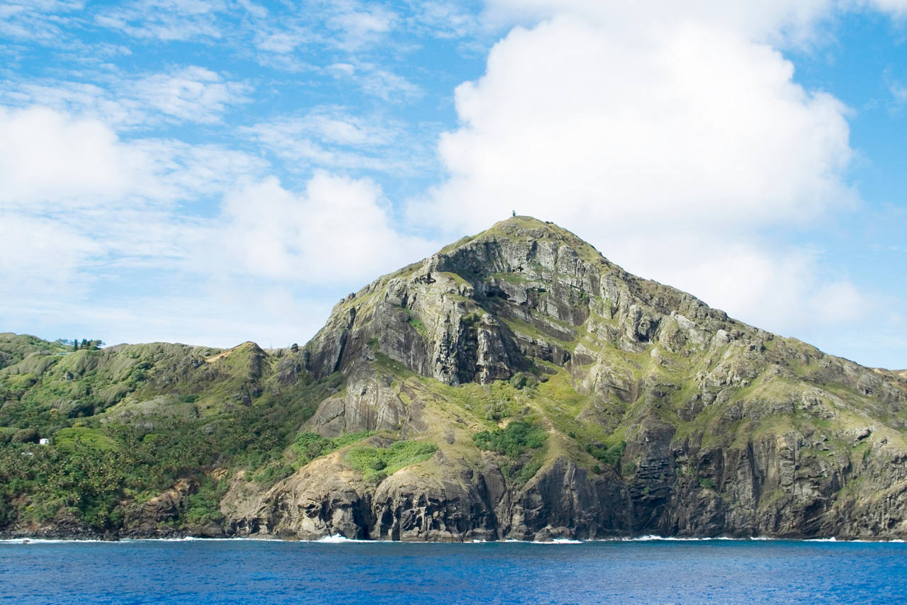 Ein atemberaubender Blick auf eine üppig grüne Insel, die unter einem strahlend blauen Himmel aus dem Meer emporragt | MSC Cruises