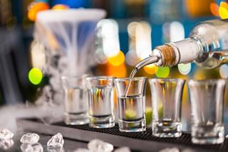 A bartender prepares a selection of vibrant cocktails at a lively bar counter | MSC Cruises