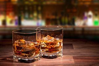 Two glasses of whiskey sit on a wooden table, creating a warm atmosphere for relaxation | MSC Cruises