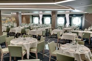 Spacious dining area with elegantly set tables and large windows, inviting guests to enjoy their meals | MSC Cruises