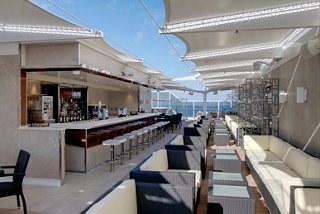 A bright and inviting bar area on the MSC Seaside, overlooking the sea with comfortable seating and a stylish design | MSC Cruises
