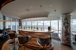 A spacious bar area with panoramic windows offering views of the sea, inviting relaxation and enjoyment | MSC Cruises