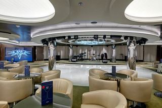A stylish lounge area with comfortable seating, a stage for performances, and a welcoming atmosphere for guests | MSC Cruises