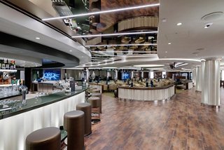 A welcoming lounge area with a bar counter, seating, and screens, perfect for relaxation and socialising | MSC Cruises