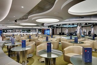 A spacious lounge area featuring round tables and comfortable seating, perfect for relaxation and entertainment | MSC Cruises