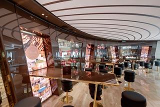 A stylish bar area on the MSC Seaside featuring elegant seating and a warm atmosphere for relaxation | MSC Cruises