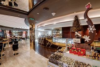 Una vista acogedora del bar de chocolate Venchi 1878, con un elegante mostrador y asientos cómodos | MSC Cruceros