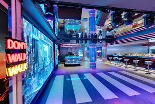 A vibrant club interior featuring dynamic lighting and a stylish bar area on the MSC Seaside | MSC Cruises