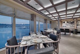 Un elegante comedor con vistas al océano, con mesas elegantes y asientos cómodos para una experiencia gastronómica acogedora | MSC Cruceros