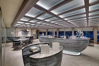 Modern restaurant with elegant tables and unique sculptures overlooking the ocean | MSC Cruises