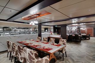 An elegant dining area featuring a large table surrounded by stylish chairs in the Butcher's Cut Steakhouse | MSC Cruises