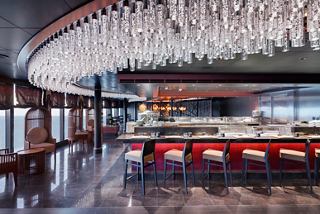 A stylish dining area in the Asian Market Kitchen featuring a sushi bar and panoramic windows | MSC Cruises