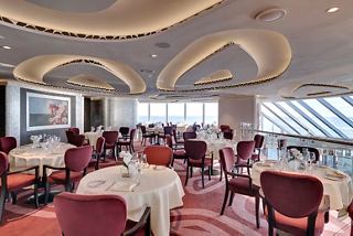 An elegant dining area in the MSC Yacht Club featuring tables and stunning sea views | MSC Cruises