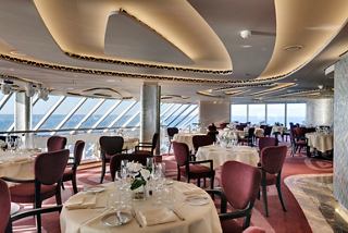 Elegant dining setup in the MSC Yacht Club Restaurant with panoramic sea views | MSC Cruises